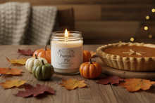 Load image into Gallery viewer, Pumpkin pie candle with a pumpkin pie and autumn decorations on a wooden table.
